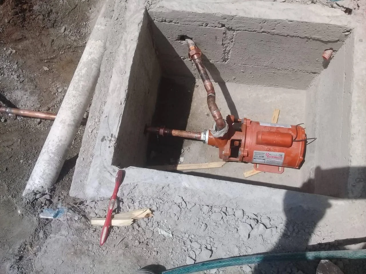 Técnico plomero trabajando instalacion de bomba en Querétaro